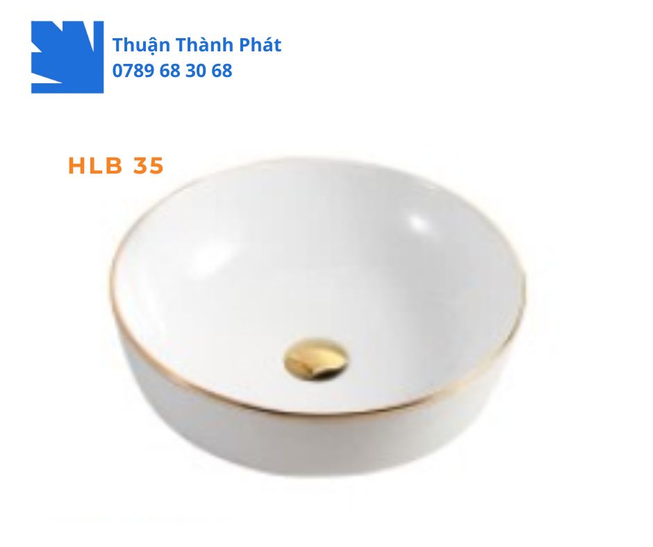 Lavabo đặt bàn Haphako HLB 35 hình bát tròn màu trắng với viền vàng và nút xả vàng kim.